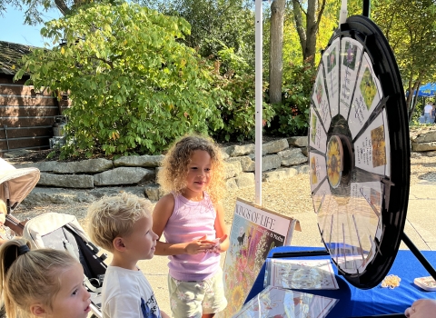 children at a table with a spinning wheel