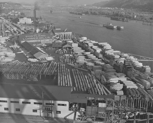 Historic black and white aerial photo of the Portland Lumber Yard along the Willamette River