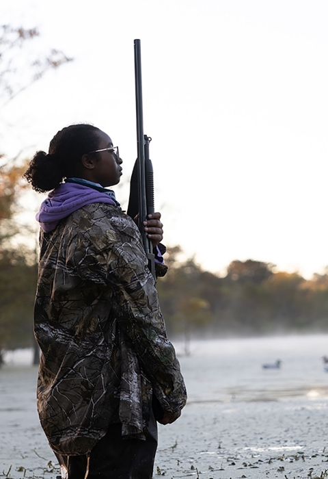 Young Woman In Hunting Gear Stands at Dusk-Wetlands