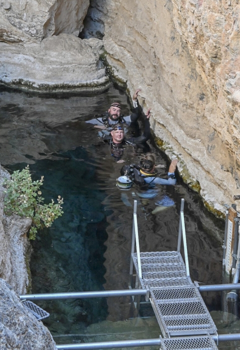 three scuba divers in water