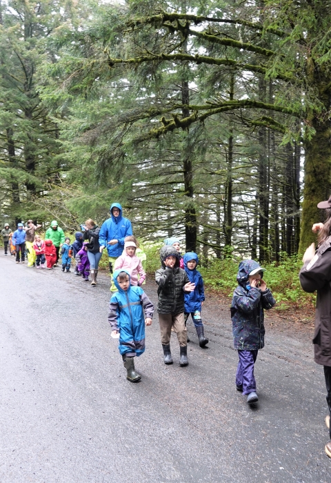 kids walking in a line down a road