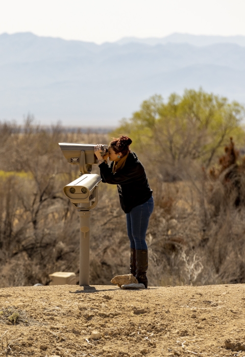 a woman looking through a spotting scope
