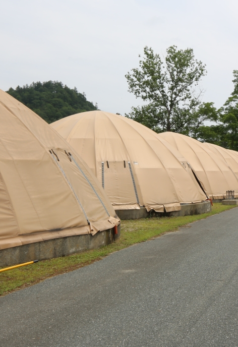 A paved road lined by circular, canvas-covered fish rearing tanks.