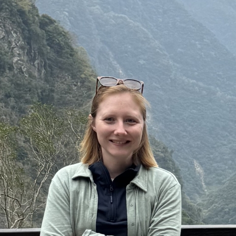 Olivia Williams with forested mountains in the background.