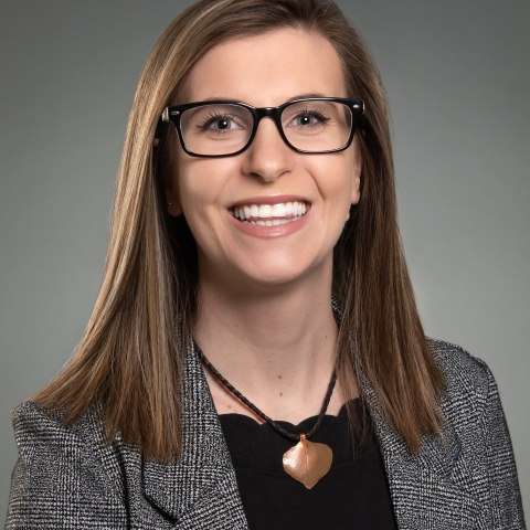 A women with glasses and short brown hair smiling