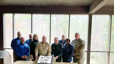 Nine agency leaders gather to celebrate signed agreement.