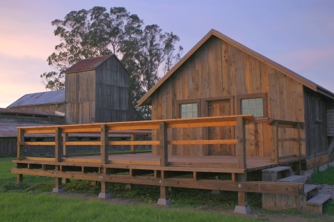 research and management techniques for wildlife and habitats A wooden cabin with the deck in the foreground and a wooden barn-like structure behind it