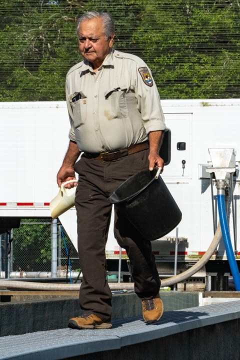 Quinault National Fish Hatchery fish culturist, Ed Lemieux, feeding fish.