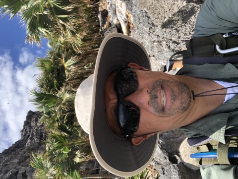 James Kwon takes a selfie with loulu, an endangered Hawaiian plant in the background. 