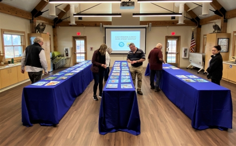 Judges reviewing artwork laid out on tables. 