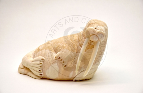 ivory carving of walrus with watermark reading Indian Arts and Crafts Board