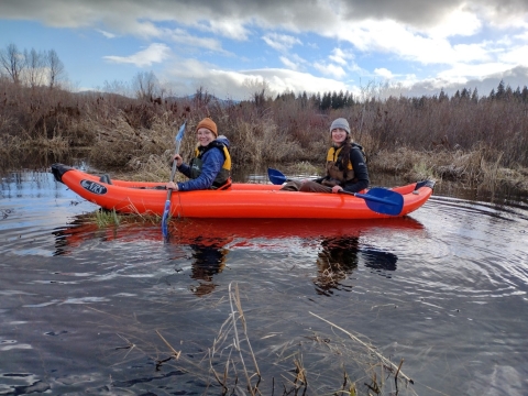 two smiling women in a kayak in a lake