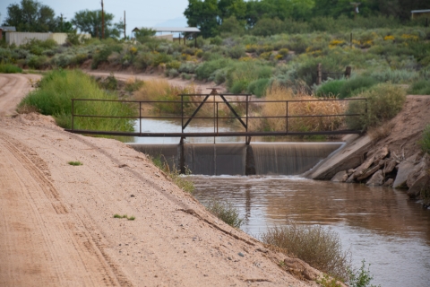 A sluice dam bridge over a irrigation ditch on a desert farm.