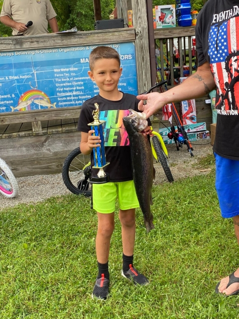 Boy holding trophy and large rainbow trout