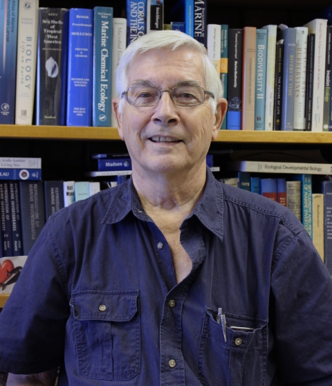 Mike Hadfield standing in front of books