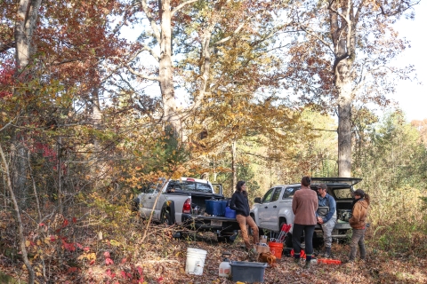 Group of people standing outdoors near pickup trucks