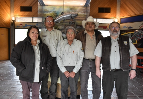 Five people stand in a row wearing USFWS logo uniform clothing.