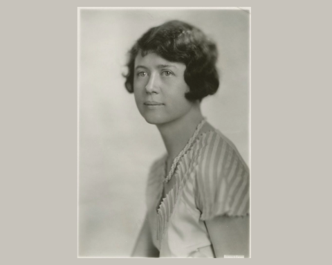 An old faded, black and white photograph shows a woman posing for the camera.