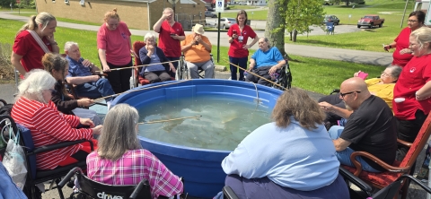 Nursing home residents fishing from trout tank