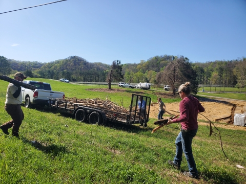 Staff from Ecological Services hauling limbs, logs, and trees to a truck and trailer