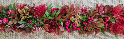 A red lei made up of different colorful plants