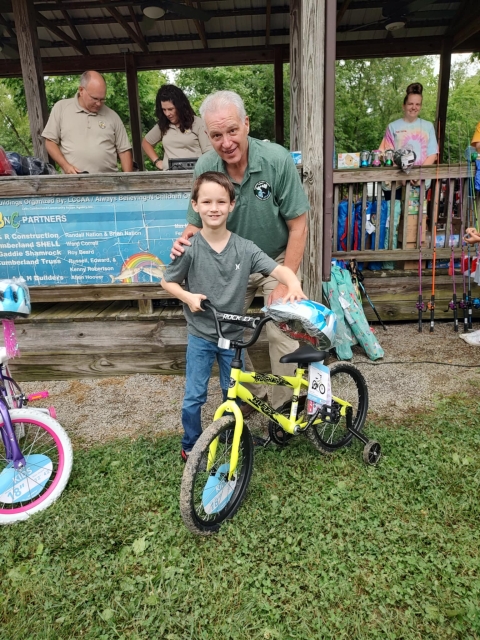 Man in uniform and boy posing with bicycle
