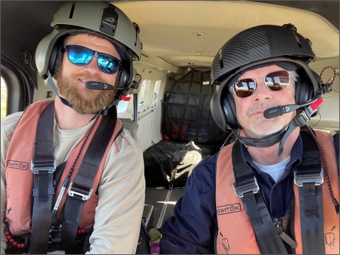 two people with helmets and seat belts on 