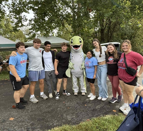 Students posing with fish mascot