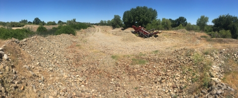 View of Merced River Ranch property with heavy machinery and mounds of gravel. 