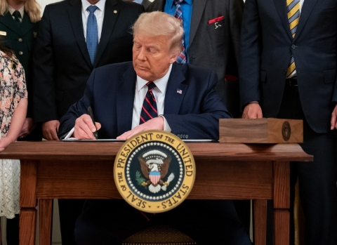 President Donald J. Trump signs bill at table