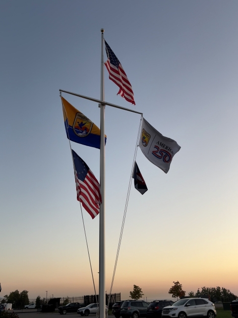 5 flags on flag pole with US at top