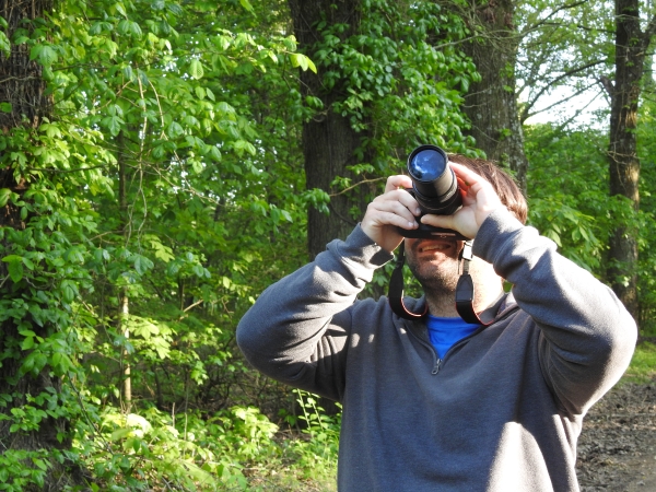 An image of someone taking a picture in the woods.