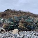 colorful wire boxes litter the rocky shore