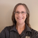 A woman wearing a dark gray shirt.