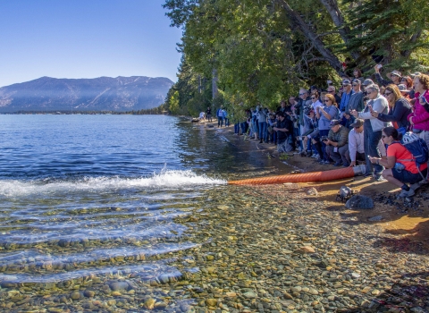 a group of people standing next to a lake 