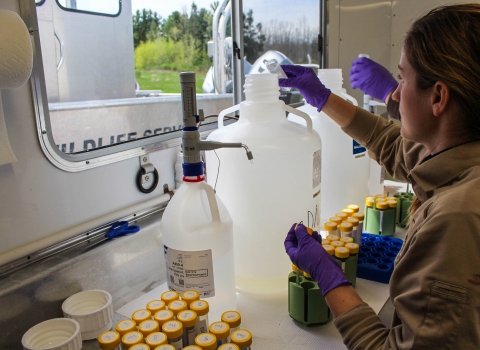 Biological technician processing samples in eDNA trailer.