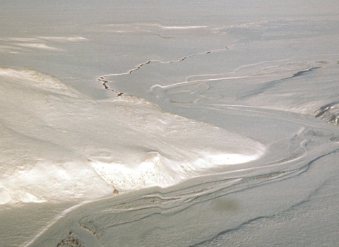 a snow scene showing topography including hills and a river from an aerial view