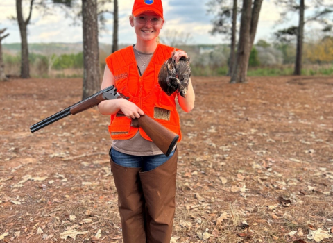 ACE Fellow Elena Campbell wearing blazing orange holds three quail she successfully harvested while hunting at Buckeyes Plantation.