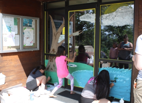 Children paint on the doors of a visitor center