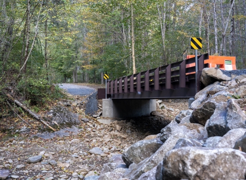 A bridge crosses a dry creek bed. 