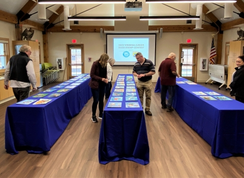 Judges reviewing artwork laid out on tables. 