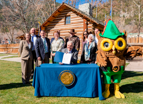 A group of people standing behind Nevada governor Steve Sisolak during a document signing event