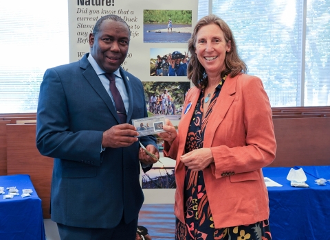 Assistant Director for Migratory Birds, Jerome Ford, stands with Director Martha Williams as they hold the newly issued duck stamp.
