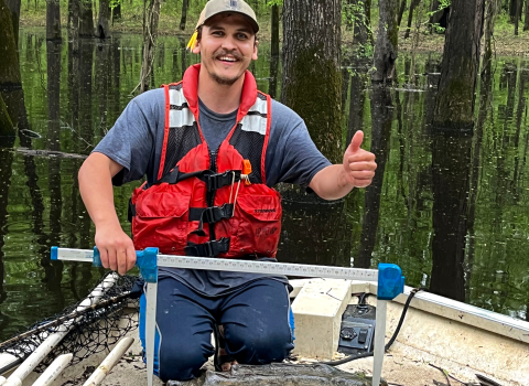 Patrick Delisle, a graduate student at the University of Southern Mississippi, poses with an alligator snapping turtle he caught during surveys conducted at the Theodore Rosevelt National Wildlife Refuge, Miss. April 18, 2024. (Photo by Bones Glorioso, United States Geological Survey)