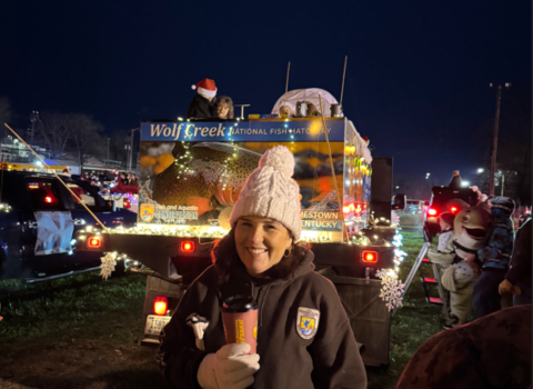 USFWS employee in front of decorated distribution truck