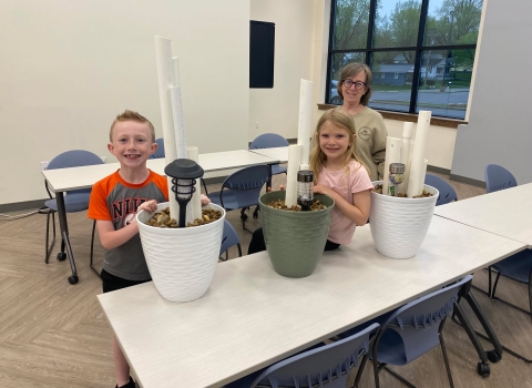 Three people smiling with their DIY frog hotels