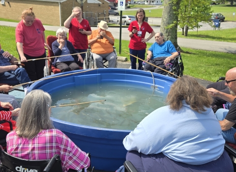 Nursing home residents fishing from trout tank