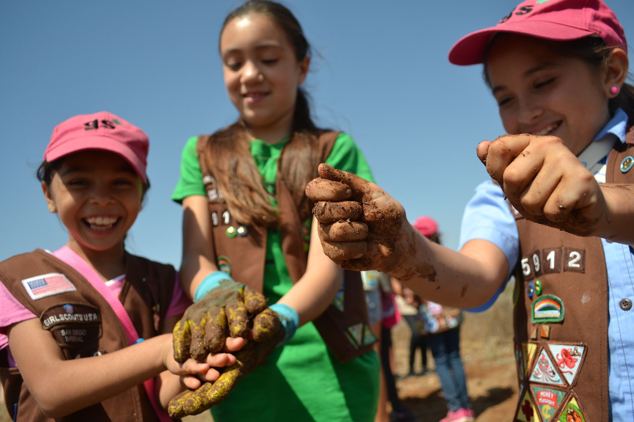 Girl scouts run soil through their hands