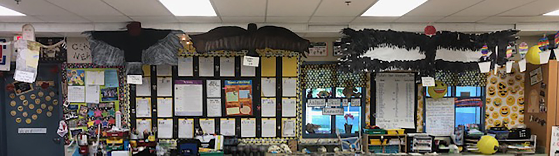 A classroom with construction paper models of a human, turkey vulture, golden eagle, and California condor