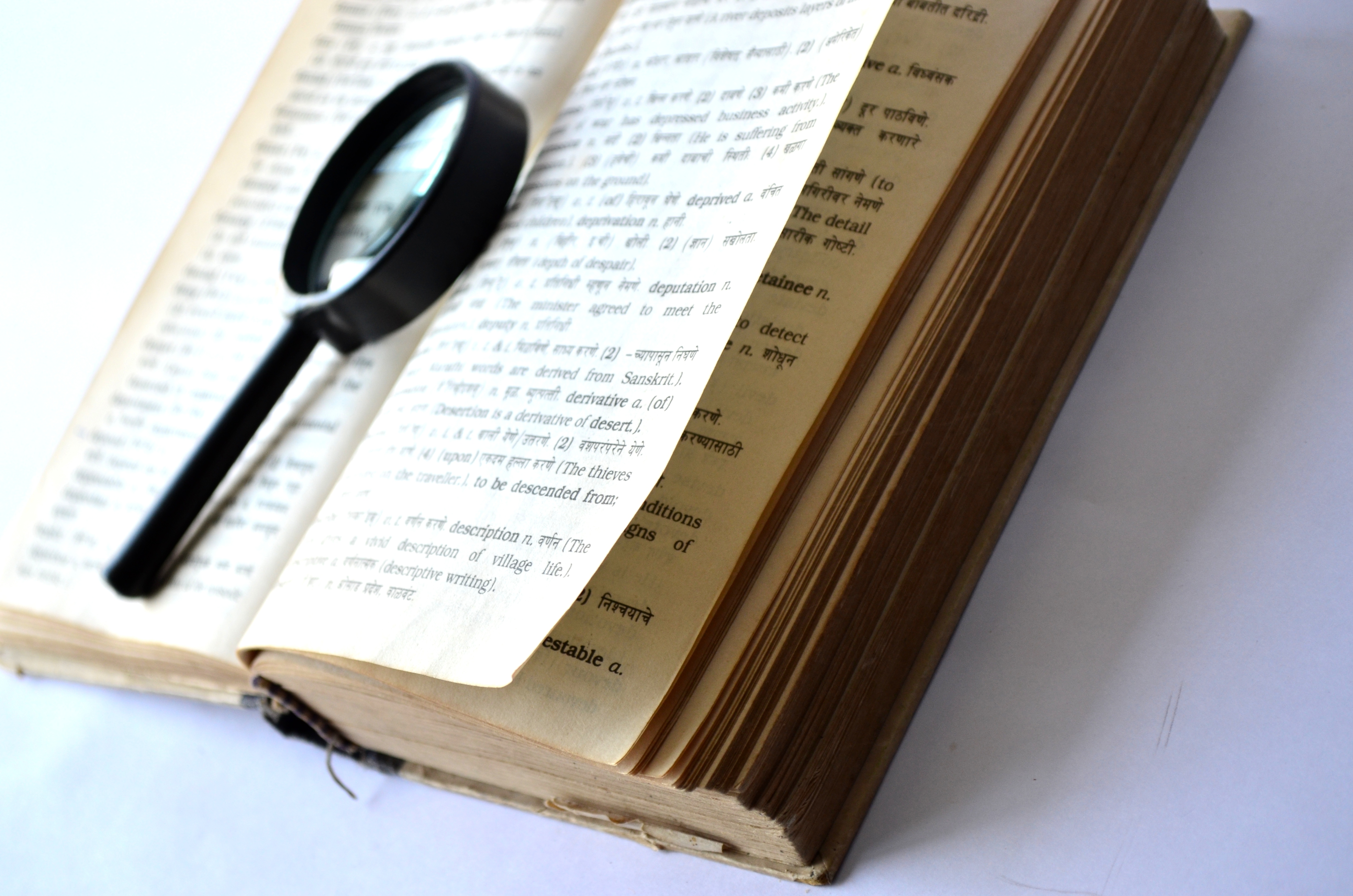 A magnifying glass sits atop an open book